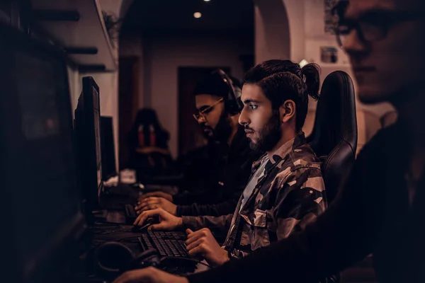 Corner cluster of higher-spec gaming stations lit by warm lamps