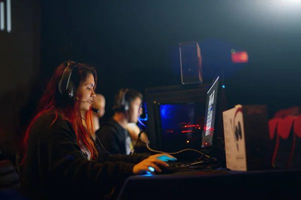 Dim, cosy gaming hall of SECRET LEVEL computer club with rows of glowing stations